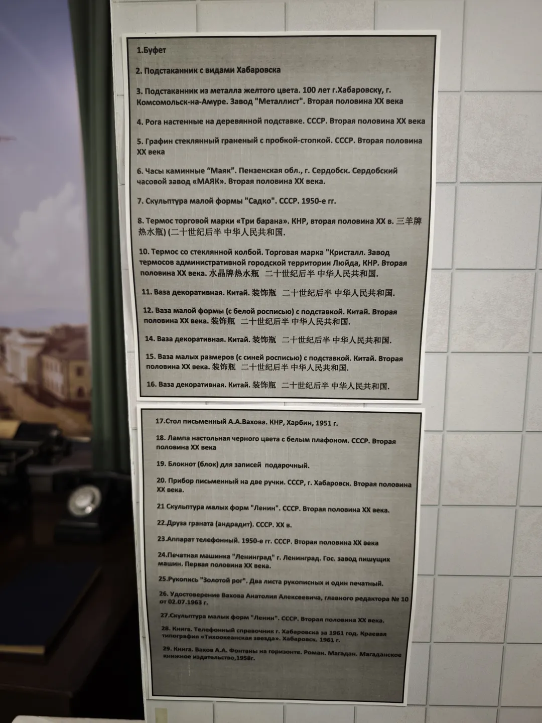 两块信息牌,上面用俄文列出了多个物品的名称和描述,背景是浅色瓷砖墙。