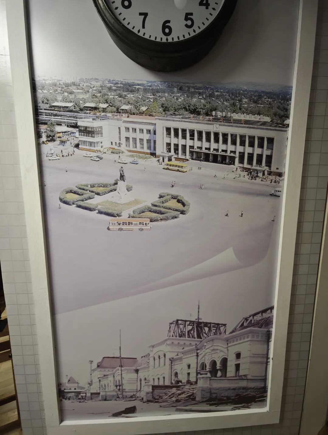 一幅黑白照片展示了一座大型建筑和广场,广场中央有一个雕塑和绿化带。上方悬挂着一个时钟,显示时间为十点十分。照片下方是另一座建筑物的黑白图像。