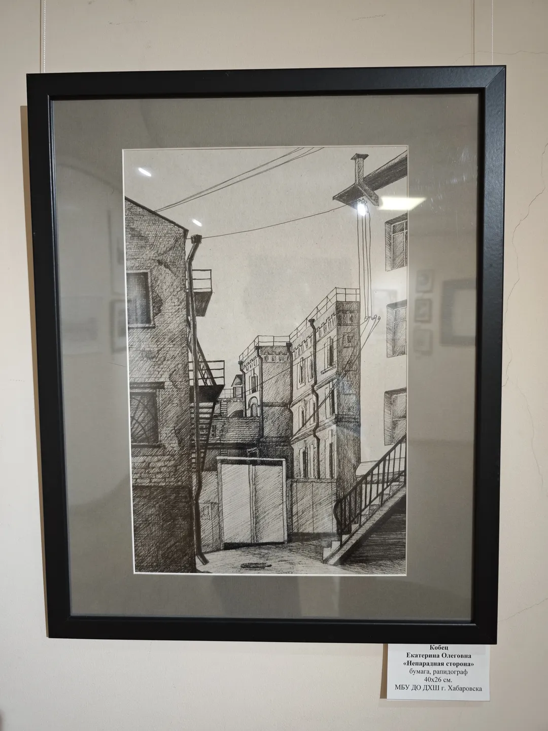 一幅黑白素描描绘了一个城市巷道场景,包含建筑物、楼梯和电线。画面细节精致,构图紧凑。