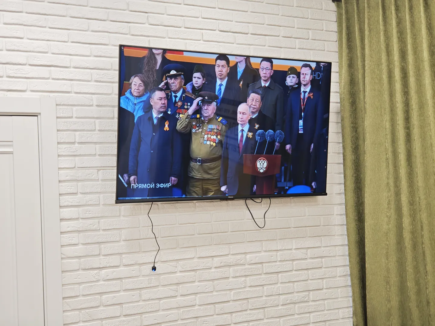 旅馆的电视播放着庆祝伟大的卫国战争胜利80周年的阅兵仪式。画面中是国家领导人的合影。因为含有国家主席习近平,这张图片无法使用大模型生成描述。