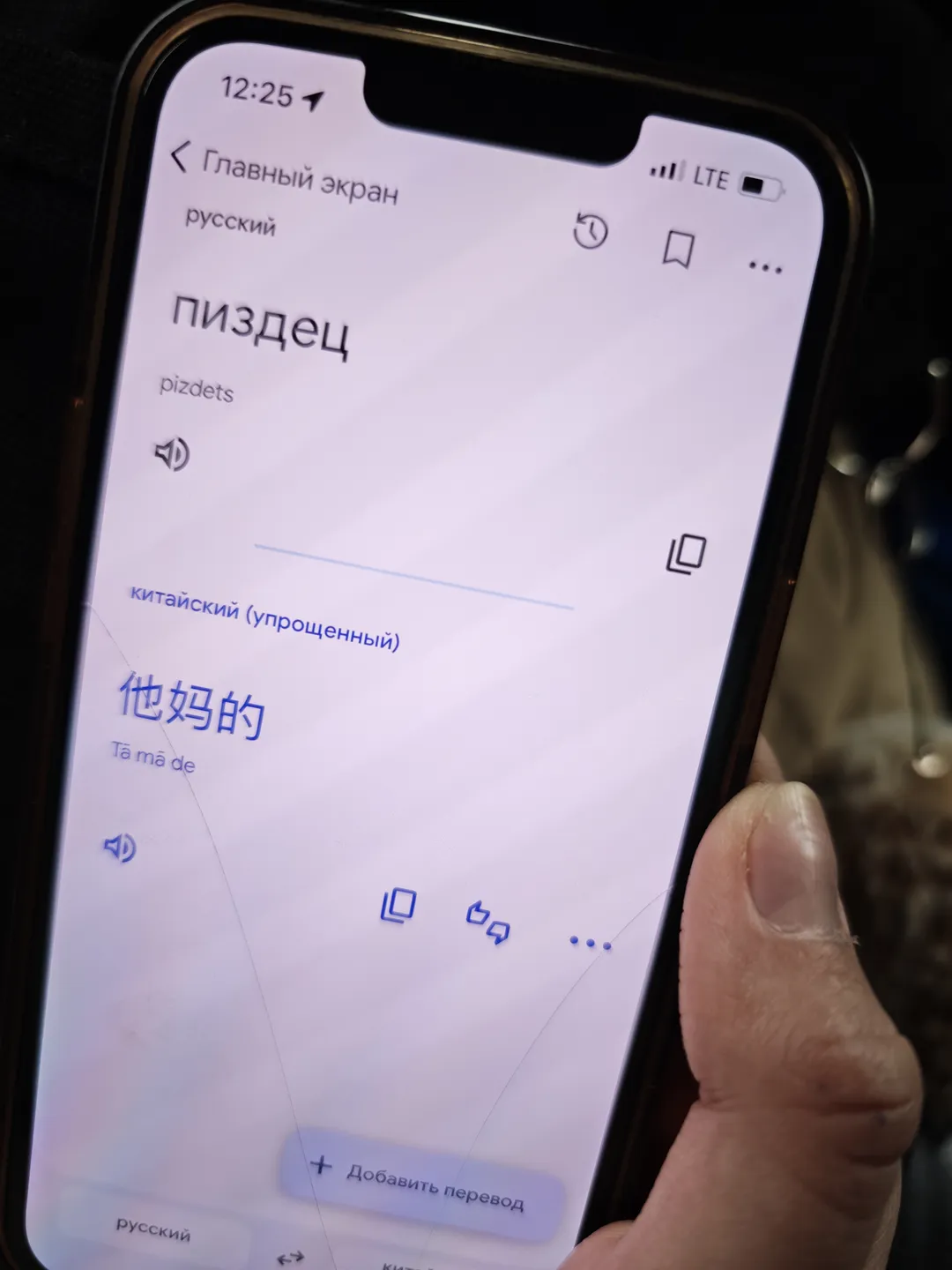 手机屏幕上显示俄语单词“пиздец”及其汉语翻译“他妈的”。屏幕顶部显示时间为12:25,信号为LTE。