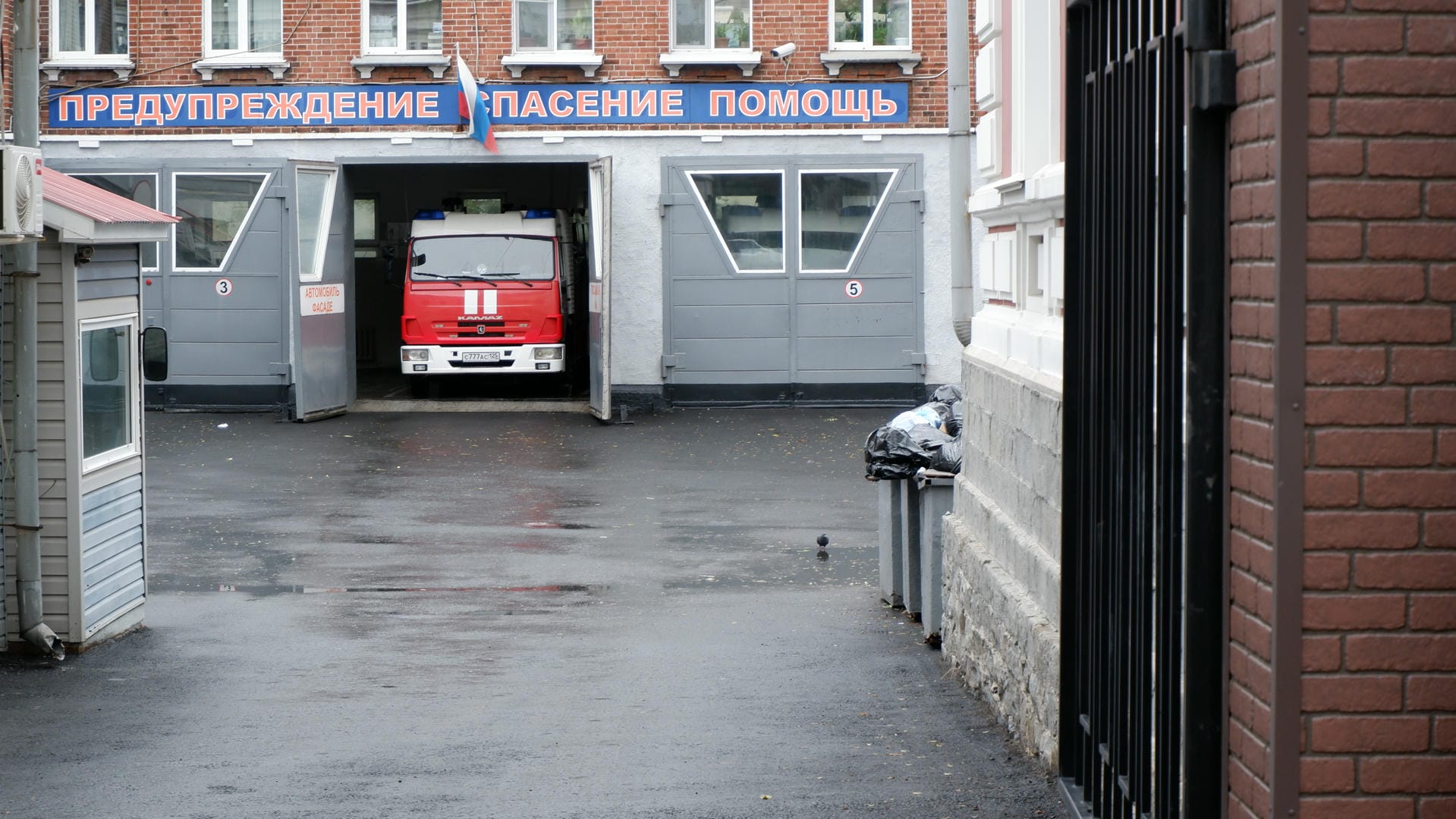 街道两旁停满了汽车，左侧是一排红砖建筑。