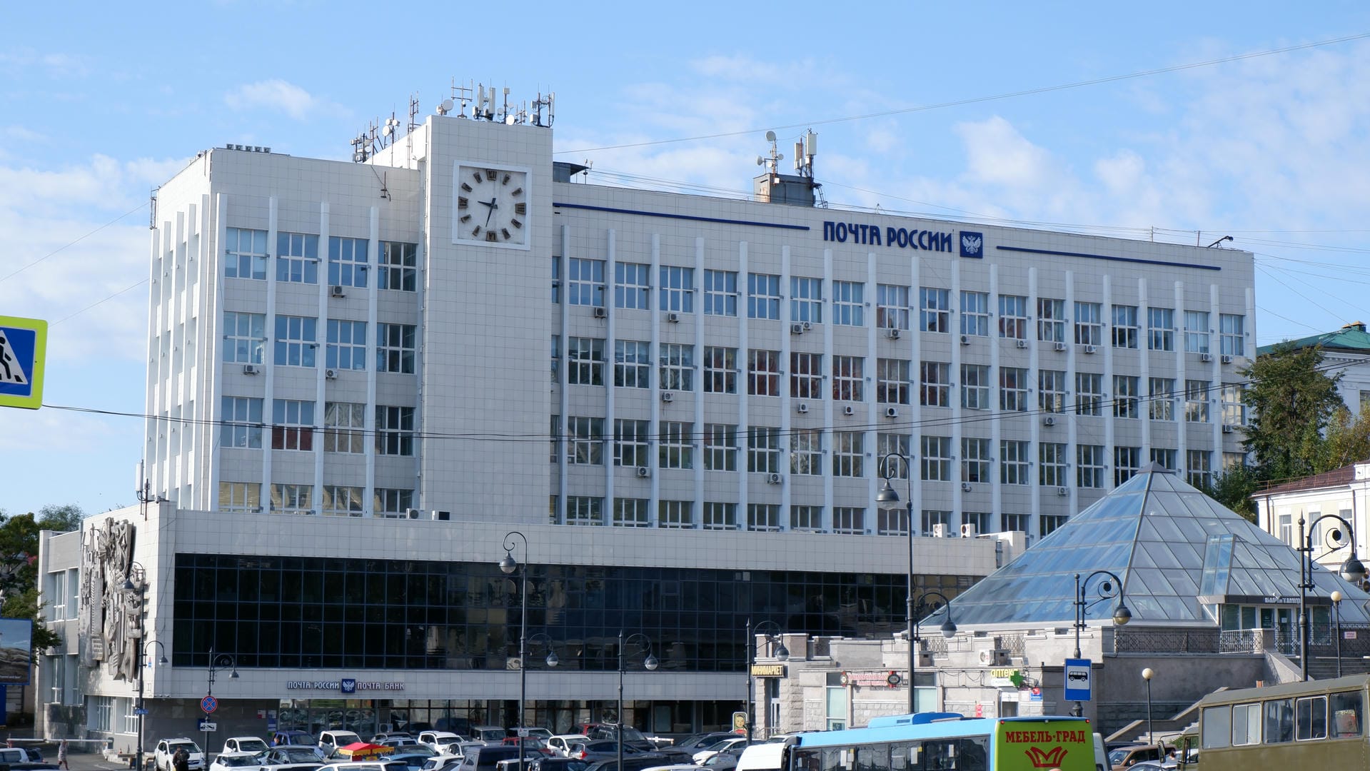 一座大型建筑，正面有“Почта России”字样，顶部装有天线和时钟。