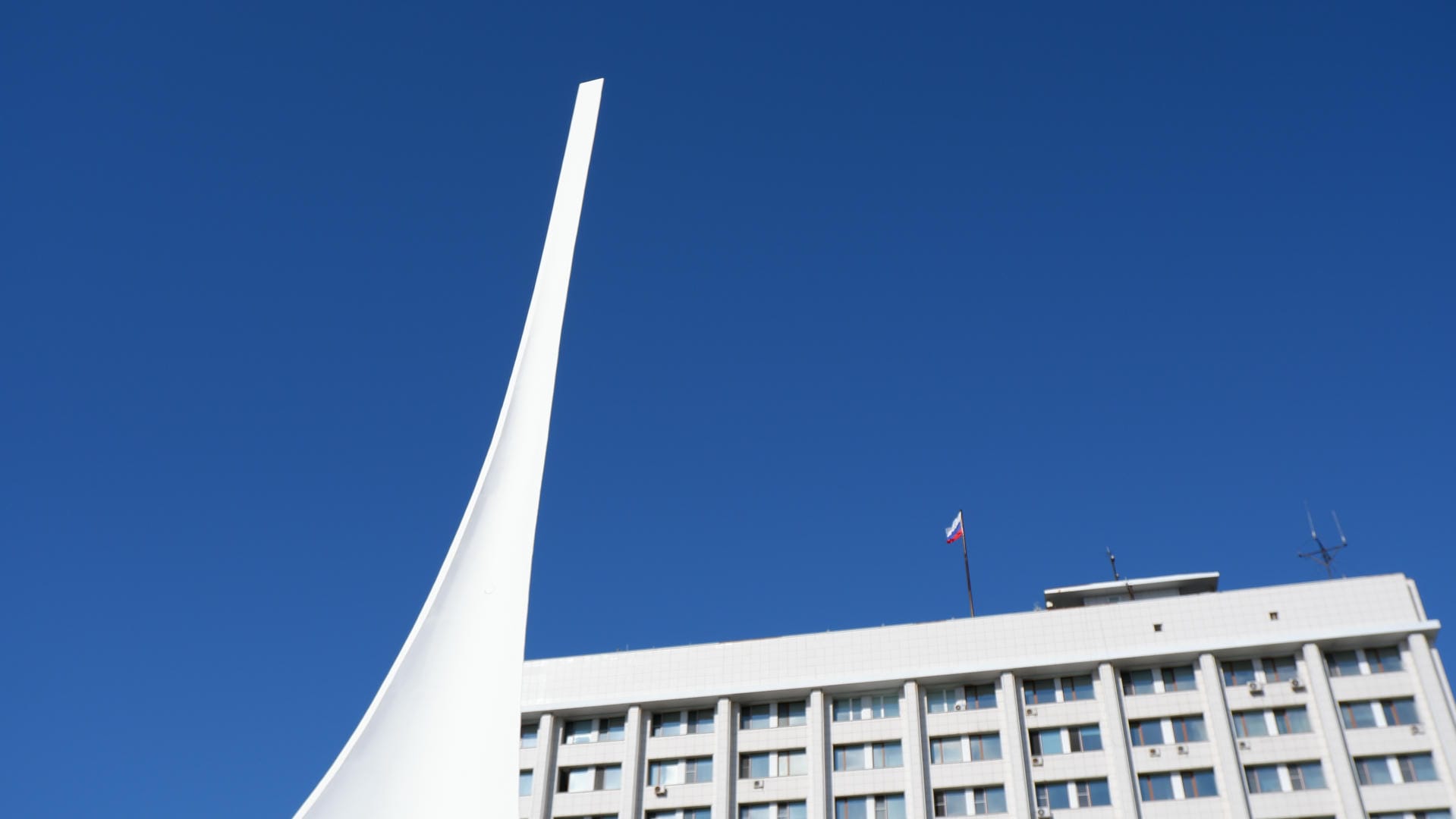 白色尖塔建筑，顶部飘扬着俄罗斯国旗。