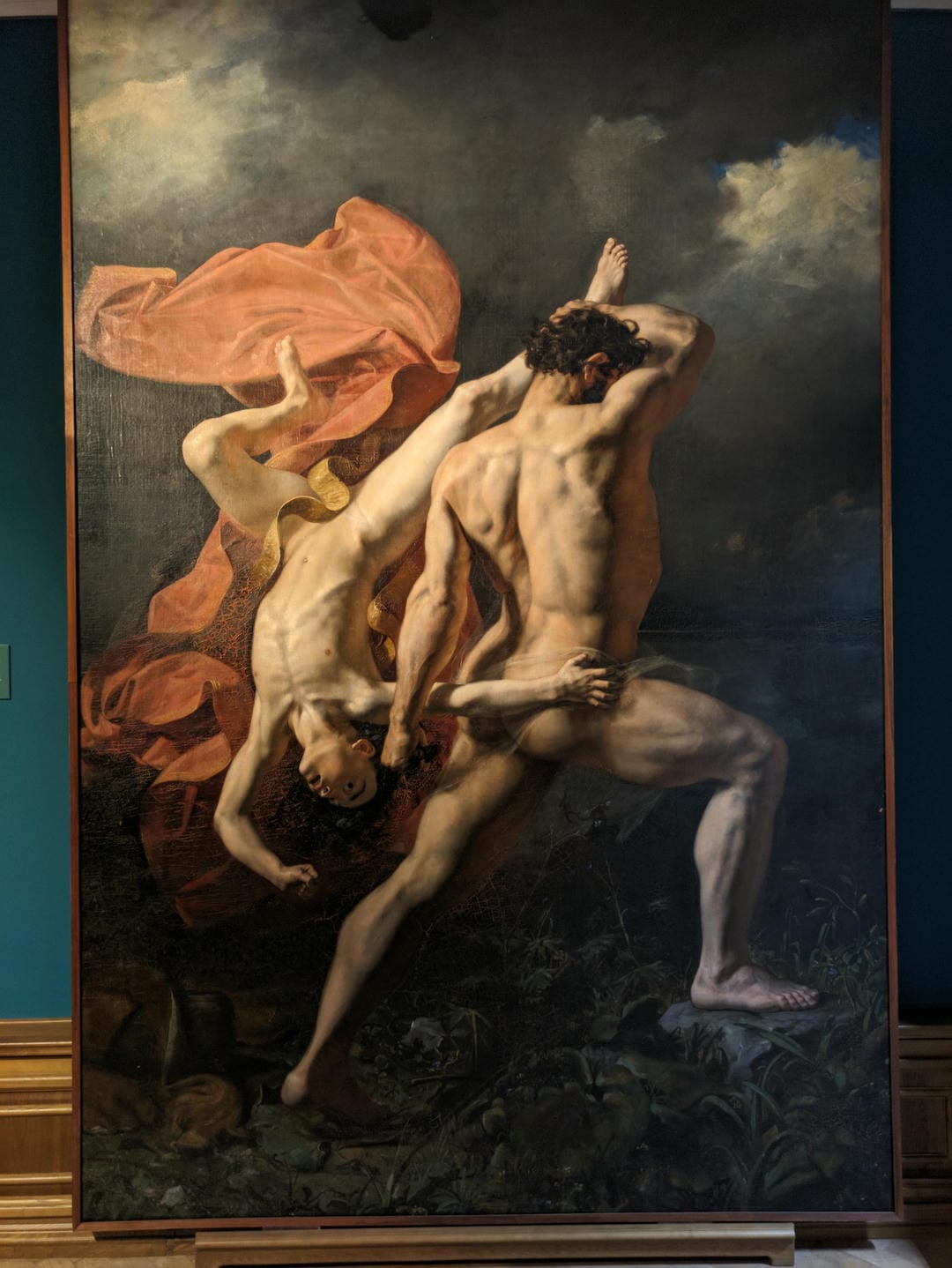 一幅画作展示了一位肌肉发达的男性正在与另一位倒下的男性搏斗,背景中有飘动的红色布料。