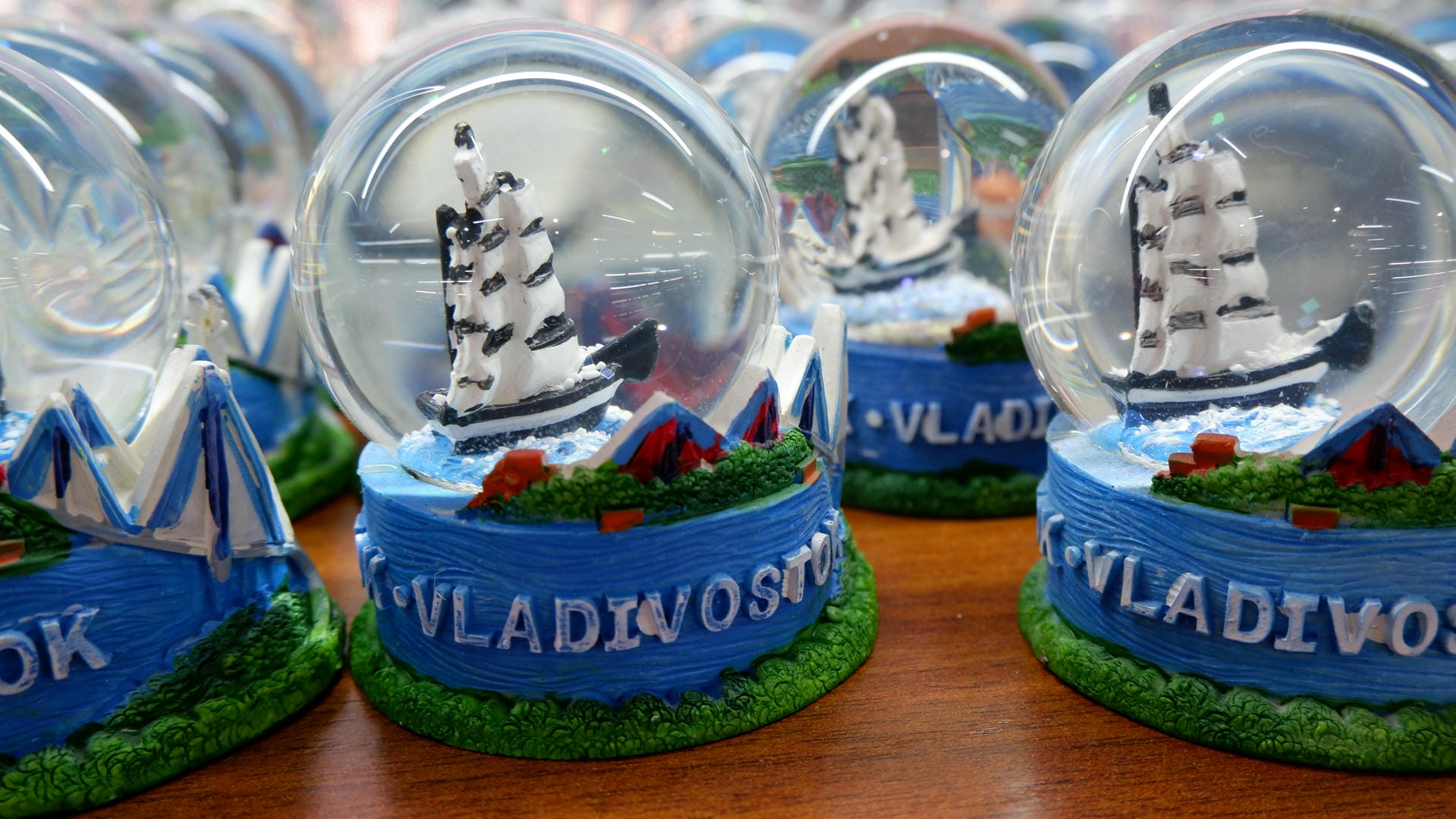水晶球内装有帆船模型，底座上有“VLADIVOSTOK”的字样，周围是蓝色的装饰。