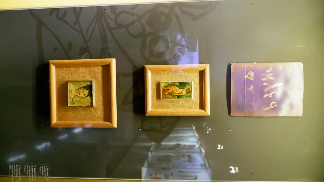 三幅小型油画，上方为紫色背景，中间为裸体女性，下方为女性肖像。