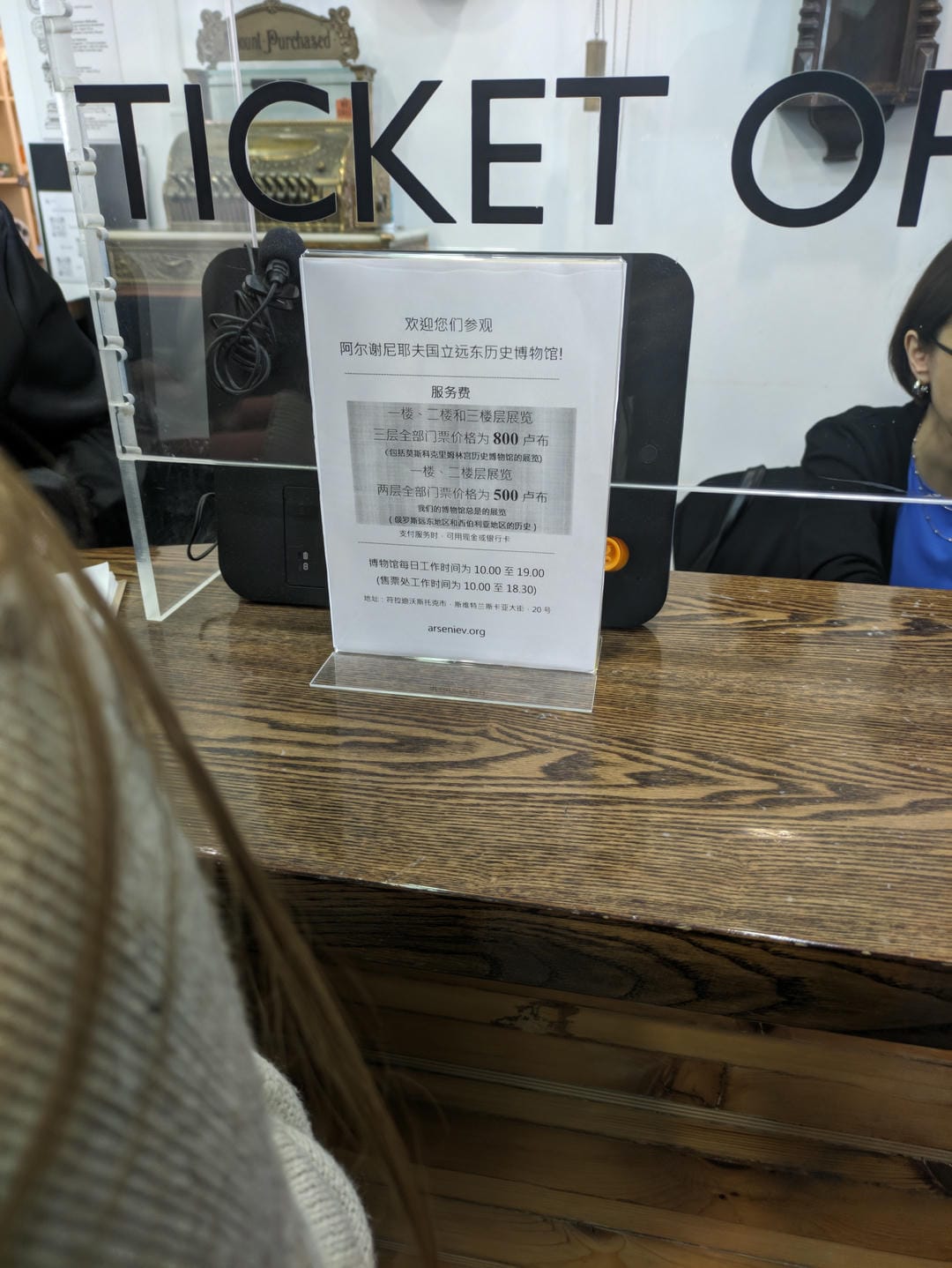 售票处前放置了一张中文告示牌,上面写着参观博物馆的信息和票价。