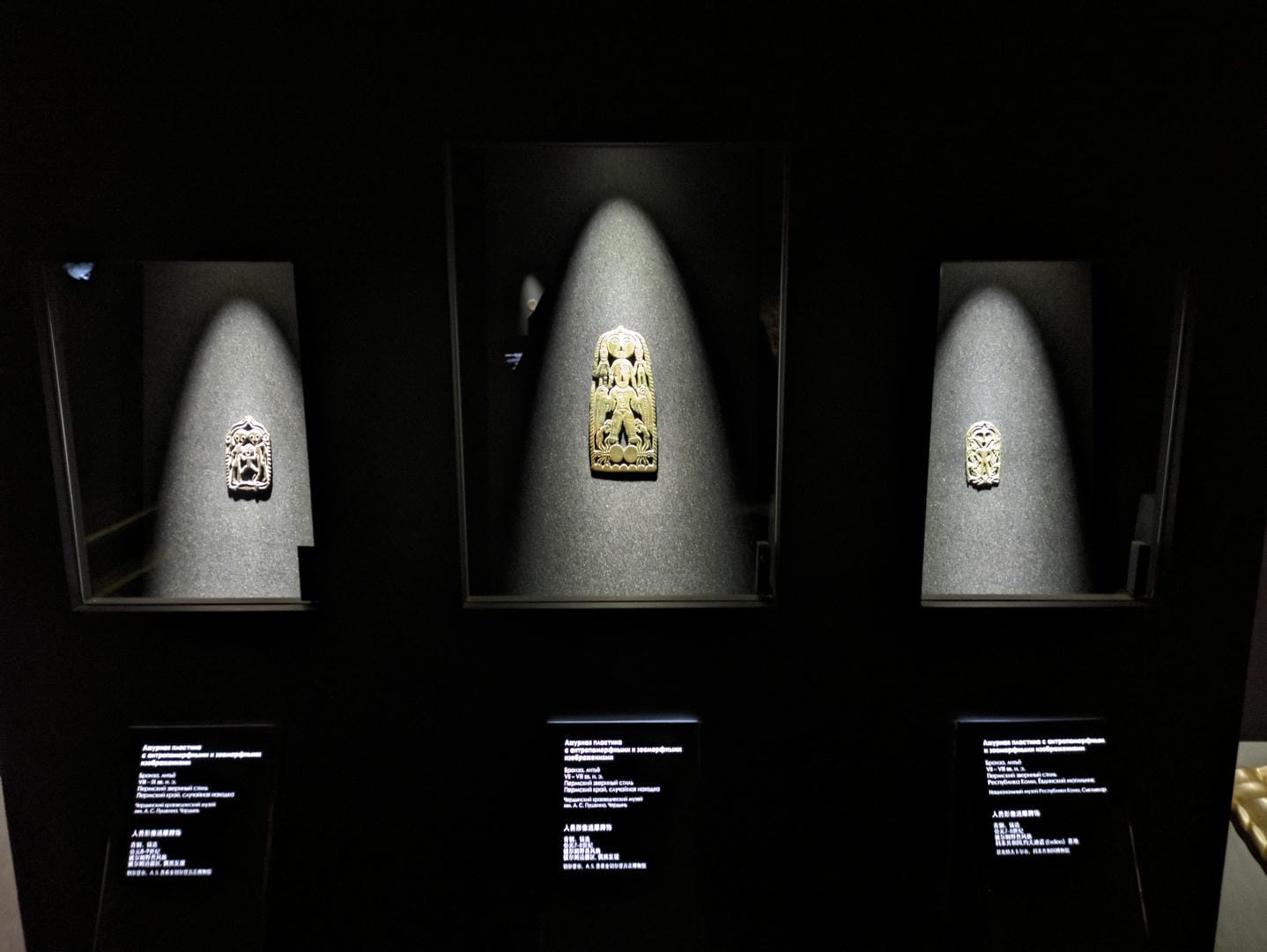 三个独立展柜分别展示着不同的小型雕刻艺术品。