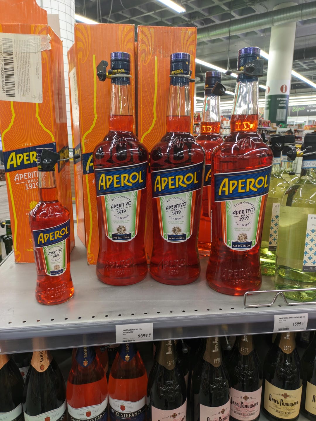 超市货架上展示着几瓶橙色的Aperol酒。