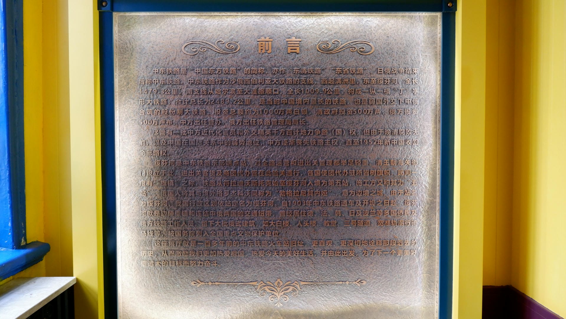 一块金色边框的金属牌匾，上面用中文书写着关于中东铁路的历史介绍。