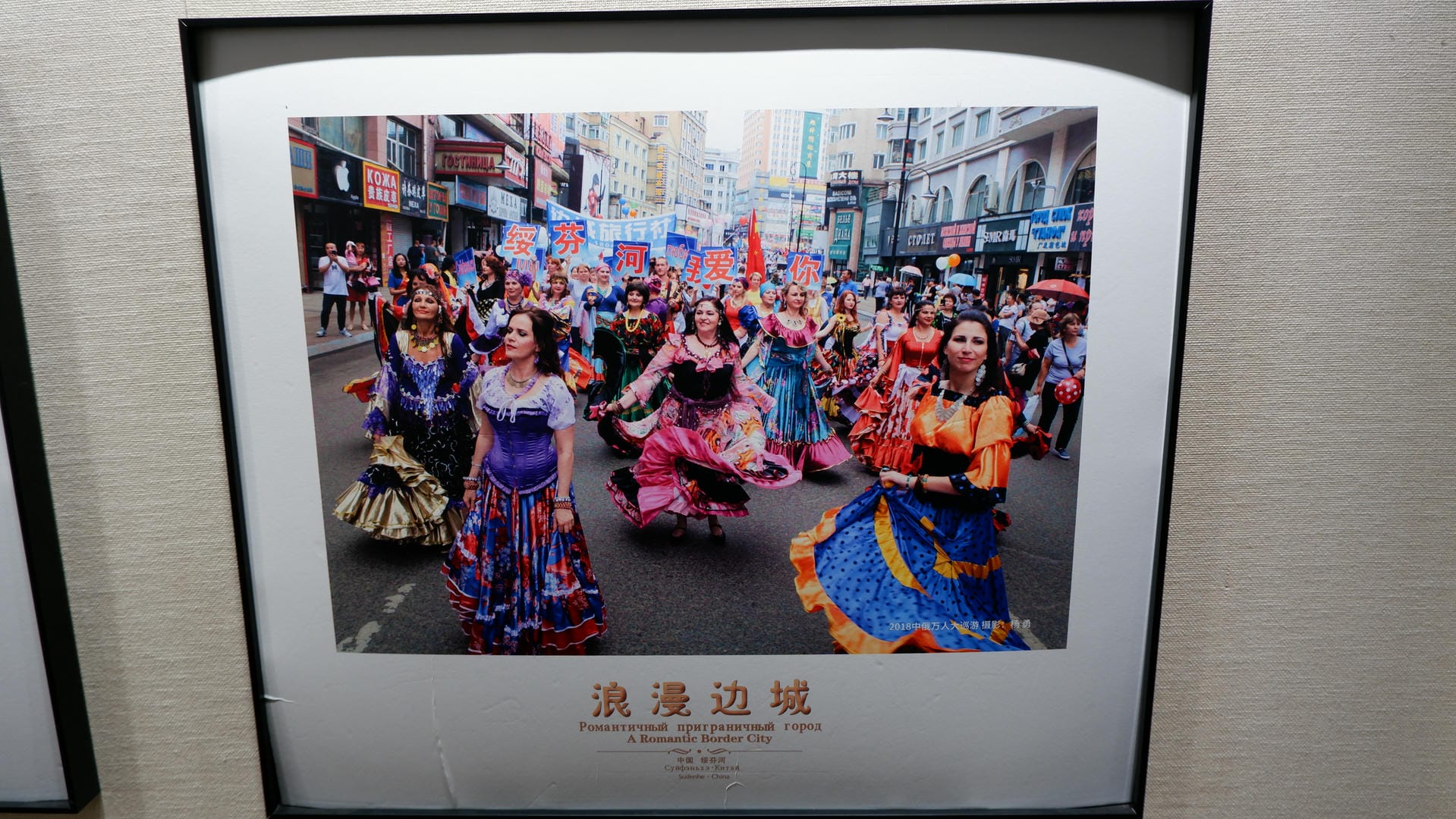 一幅画，描绘了街道上的舞蹈表演，参与者穿着彩色服装。