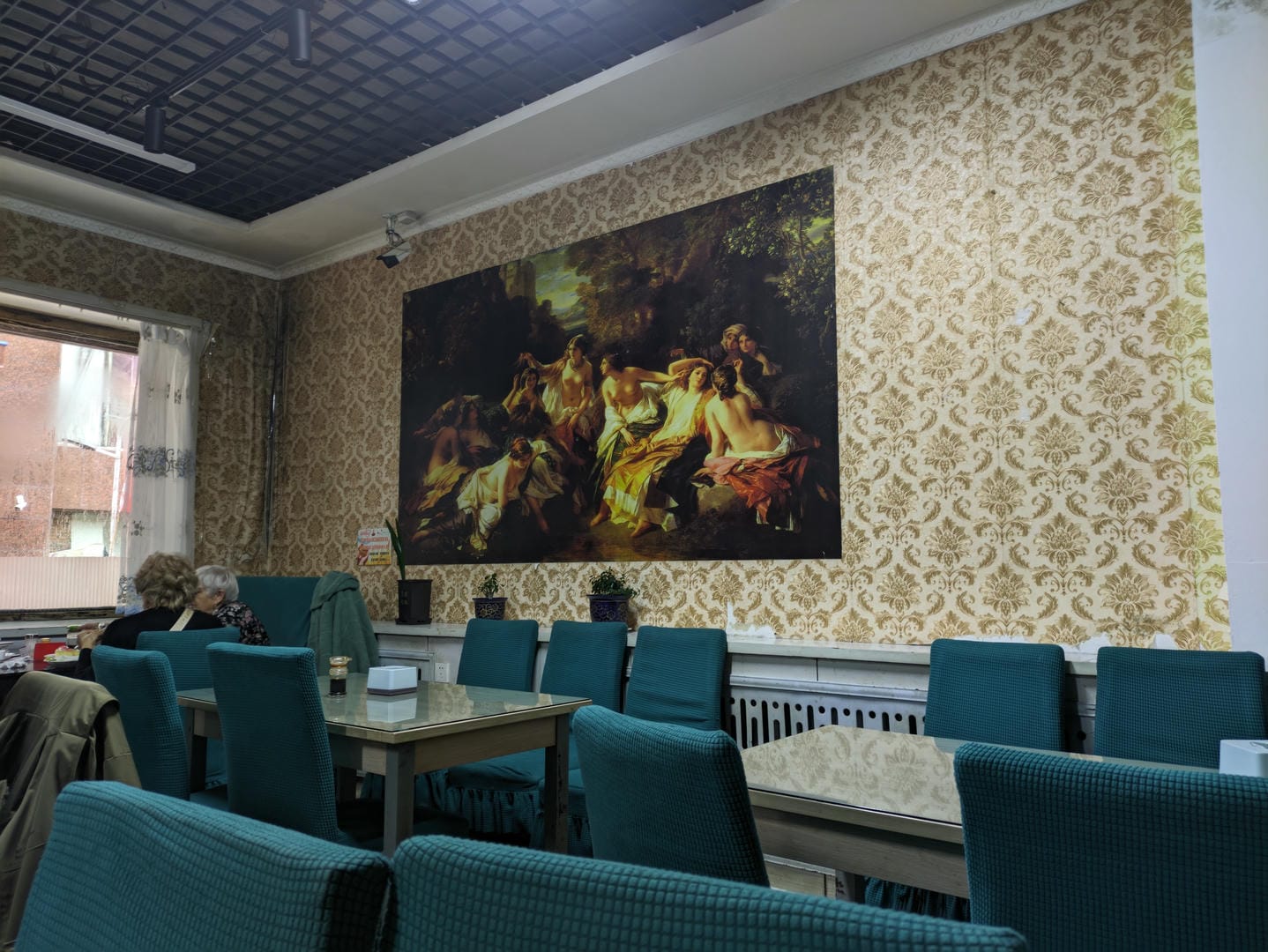 餐厅内墙上挂着一幅大型油画,描绘了古典场景。