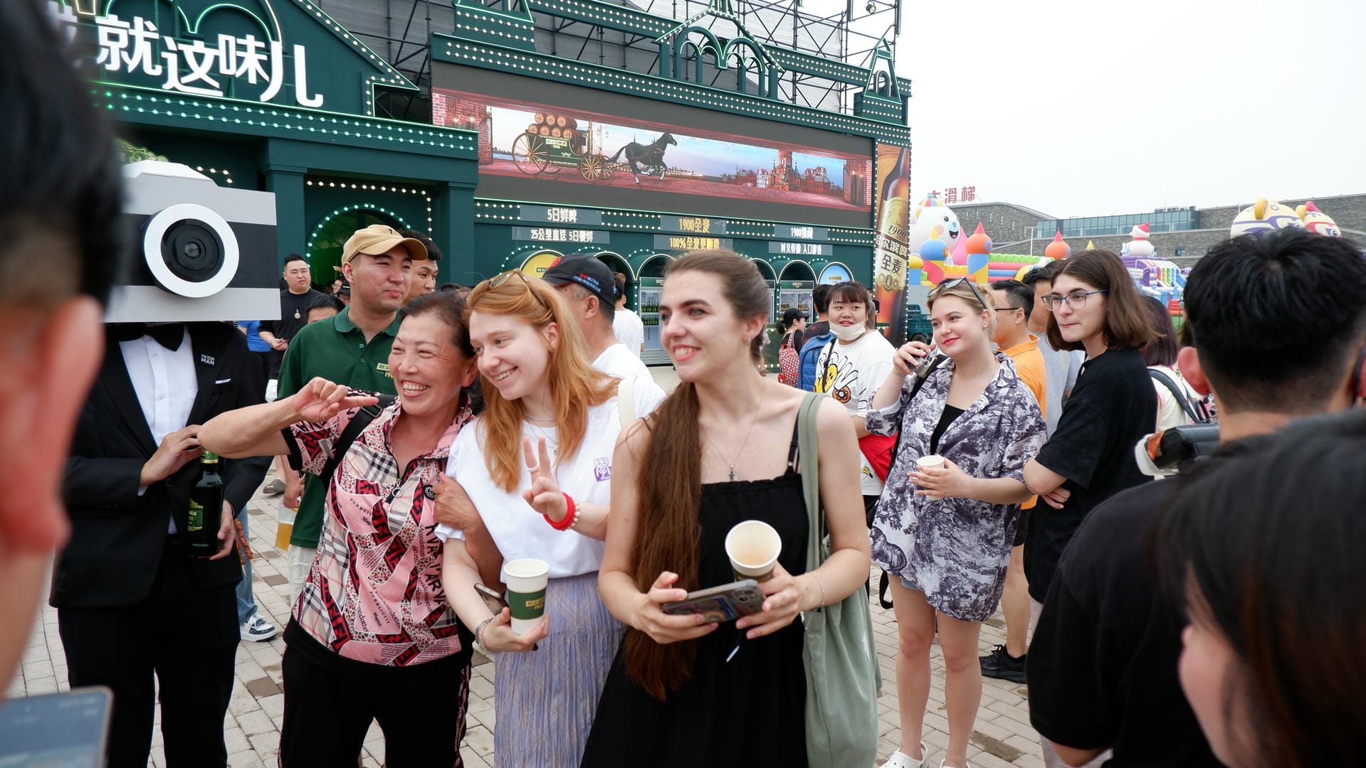 there are many people standing outside of a building with a camera