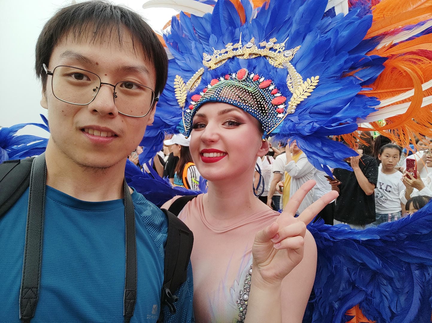 they are posing for a picture in a carnival with a blue feathered headdress